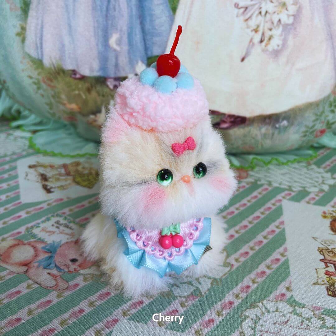 Mewlicious Collection – fluffy kitten figurine dressed as a cherry-topped dessert with a cute pink bow, handmade in UK.