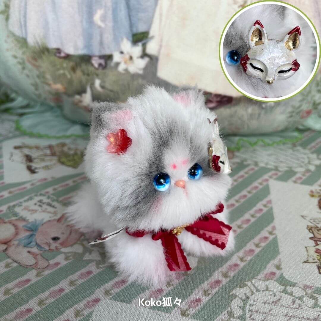 Handmade kitten from the Fairy Paws Collection, fluffy gray and white, adorned with a red bow and accessories, kawaii style.