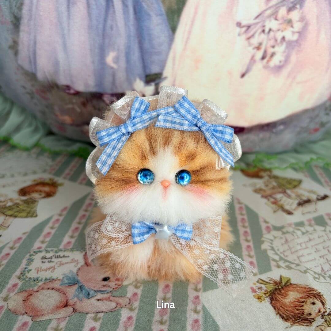 Handmade kitten from the Fairy Paws Collection, brown and white fluffy cat figurine with blue bows and lace accessories.
