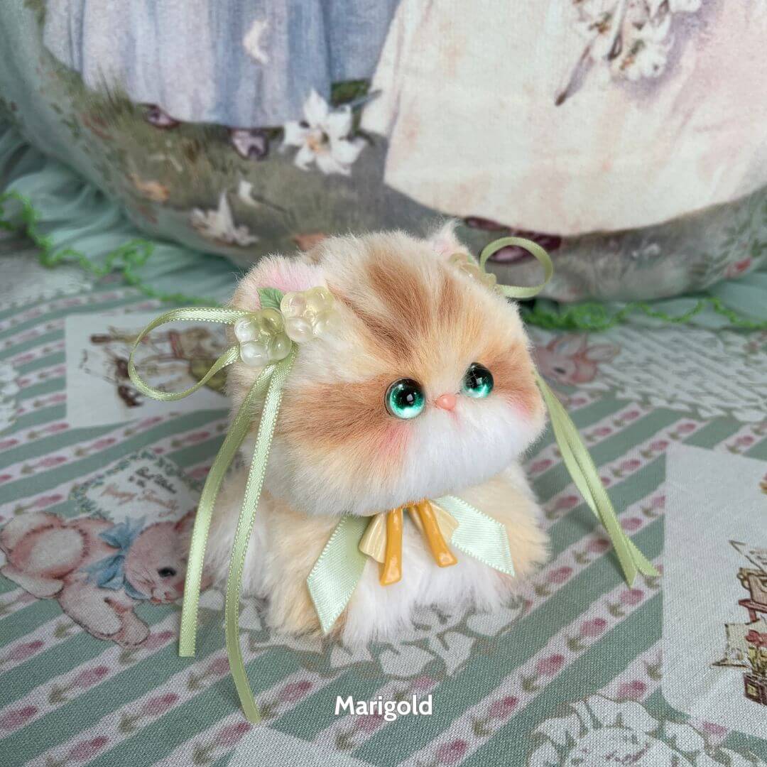 Adorable handmade kitten from the Blossom Kitten Collection, featuring fluffy fur, cute bows, and bright blue eyes.