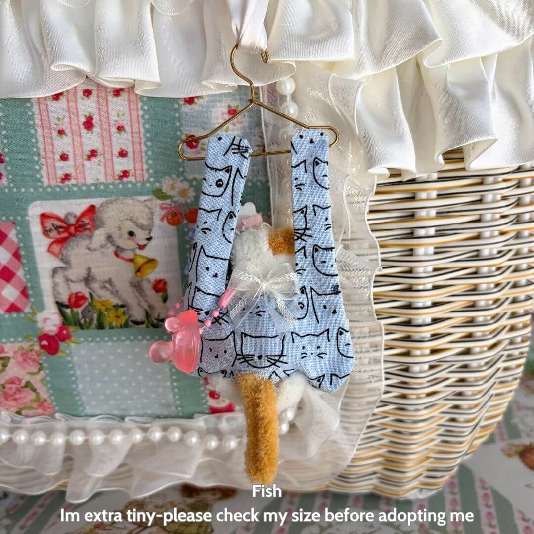 Alt Tag: Little Hanger Pals handmade kitten hanging in a blue cat-patterned outfit, tiny collectible fluffy cat figurine, cute animal decor.