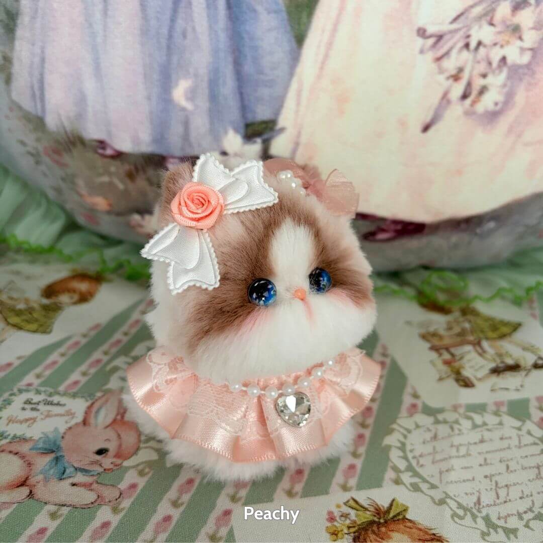 Alt Tag: Handmade kitten from the Fairy Paws Collection, fluffy kawaii cat figurine in pink dress with bow and blue eyes.