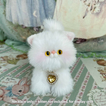 Miniature kitten figurine with fluffy white fur, wearing an Elegant Heart Necklace featuring a sparkling heart pendant.