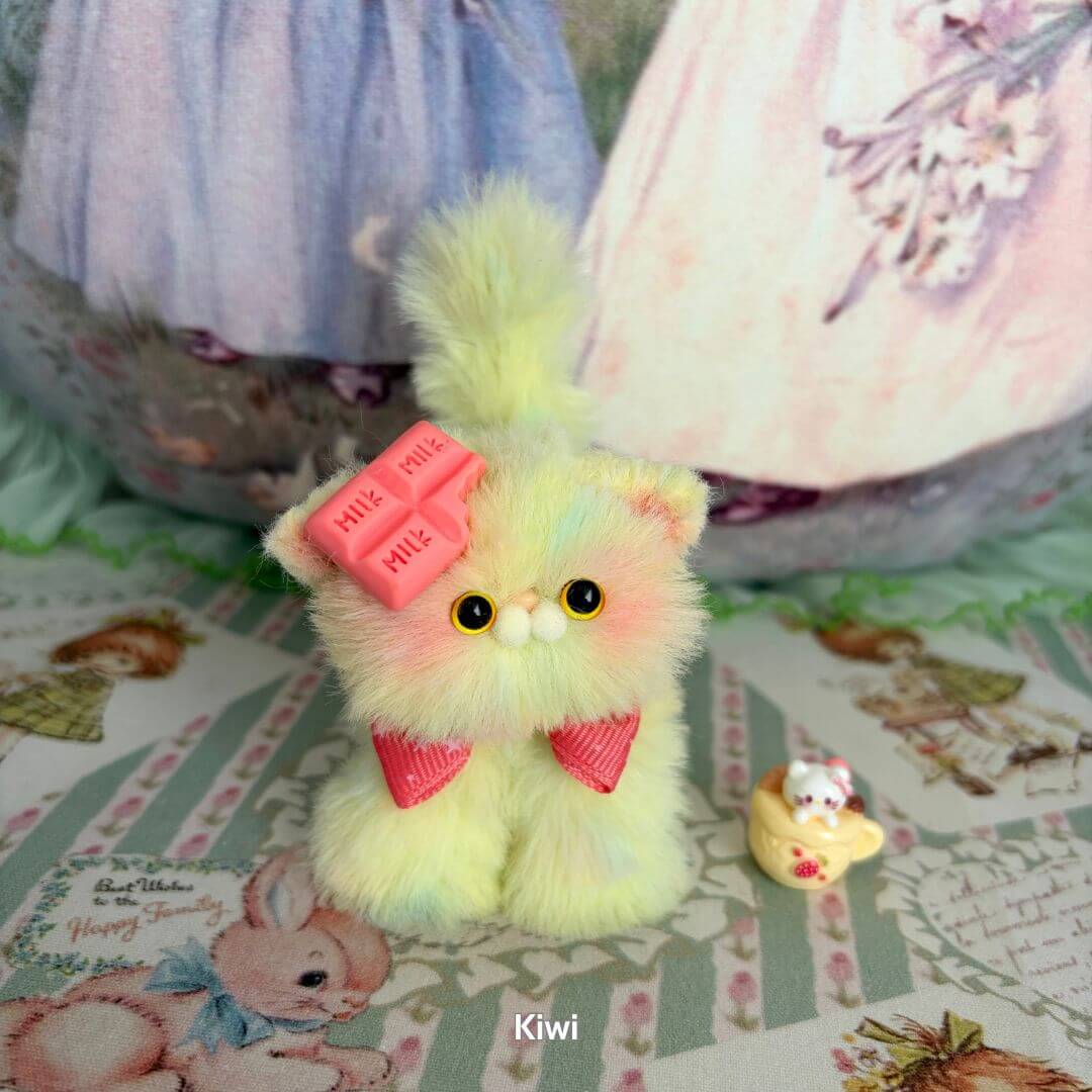 Fruity Kitten Collection: Kawaii pastel kiwi kitten with pink bows, fluffy fur, and tiny accessory, handmade collectible.