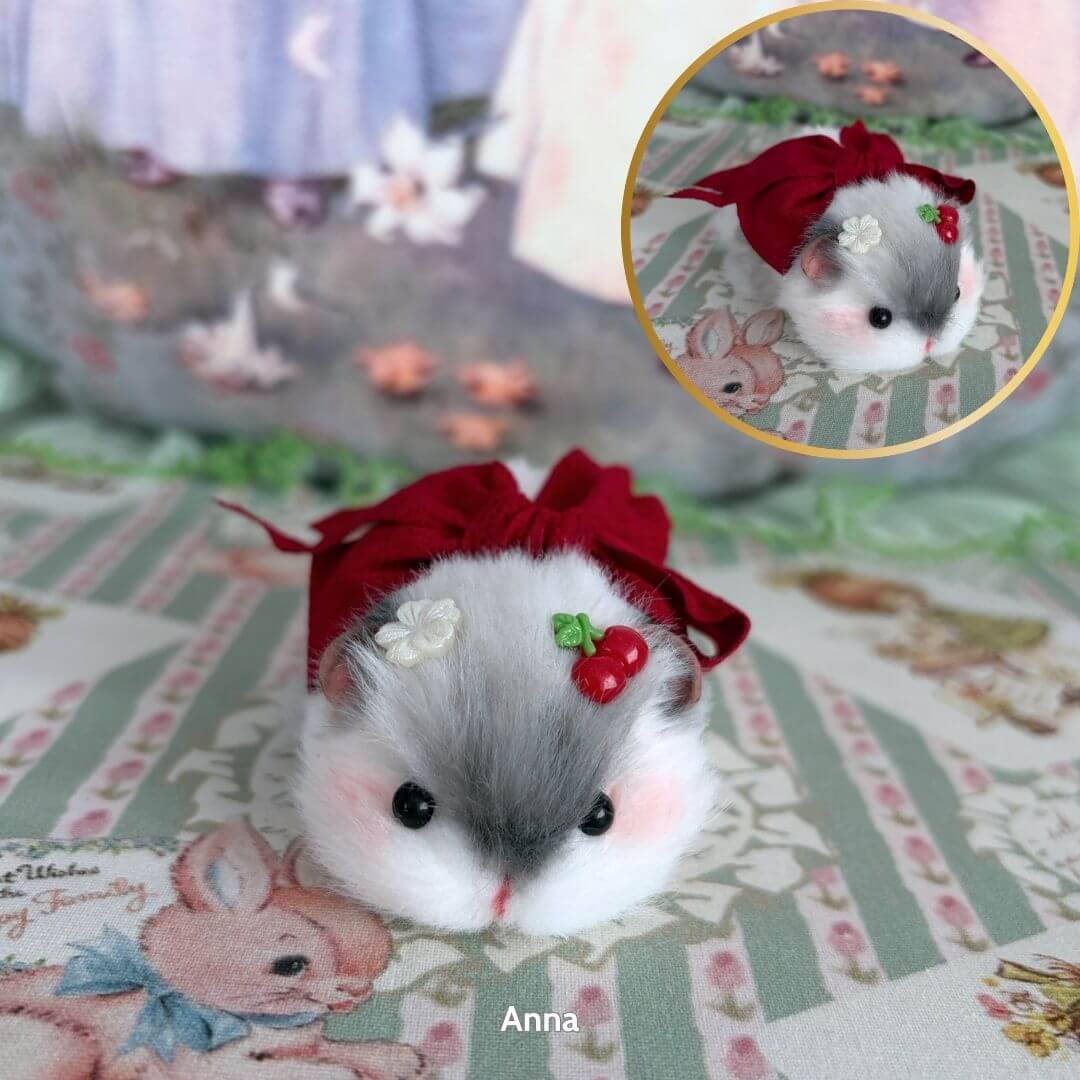 Lying Hamsters Figurines: Handmade grey hamster in red outfit with cherry and flower decor, cutely posed on a patterned surface.