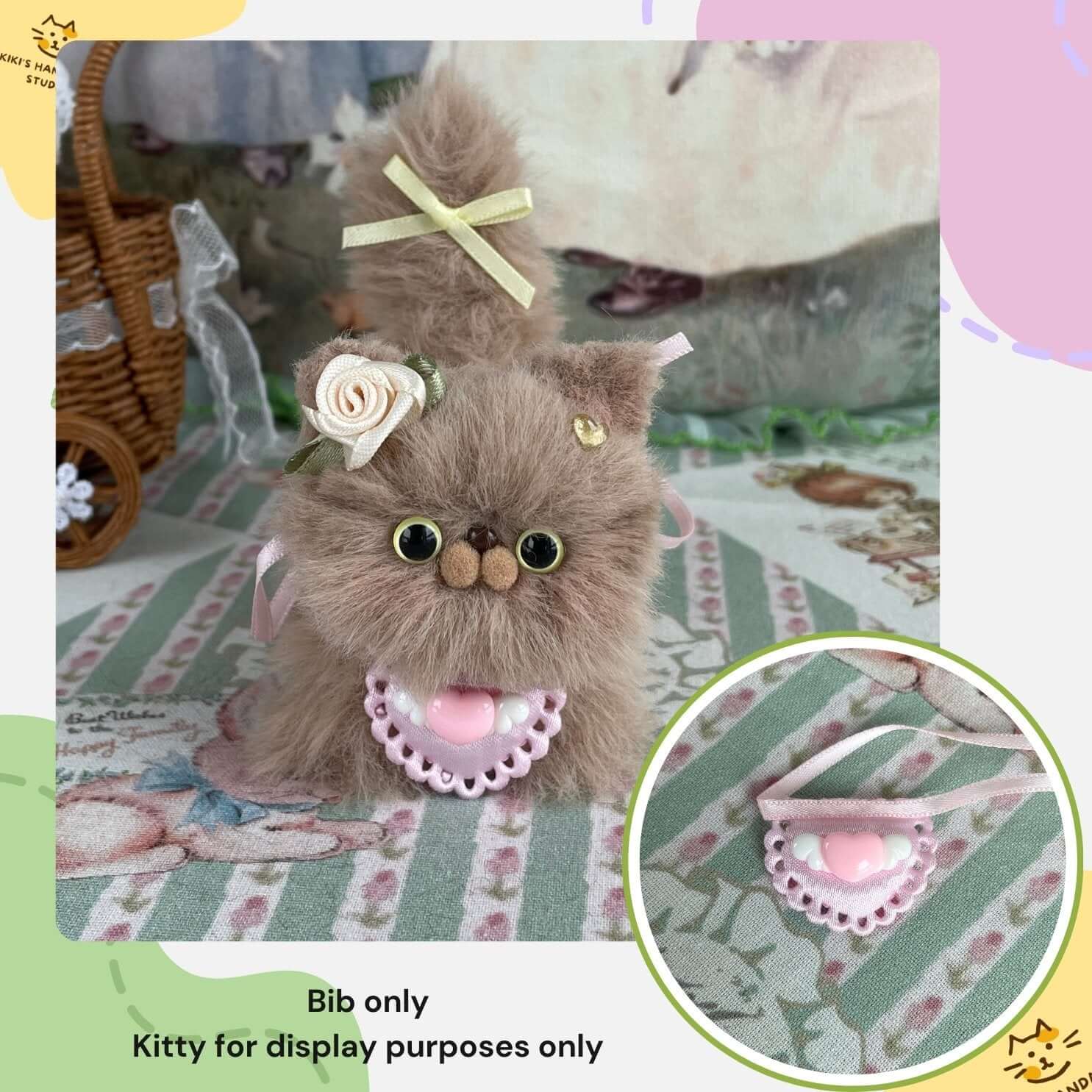 Adorable handmade mini bib for kitten plush toy, featuring a pink heart design. Note: Kitten for display purposes only.