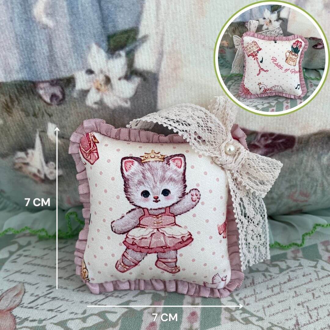 Handmade mini cuddle critter cushion featuring a kitten design, measuring 7 cm, with a lace bow, ideal for dolls or desk decoration.