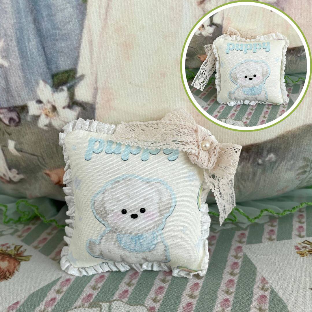Handmade mini puppy cushion with bow, perfect for dolls or desk decor, detailed plush toy accessory, crafted with delicate stitches.