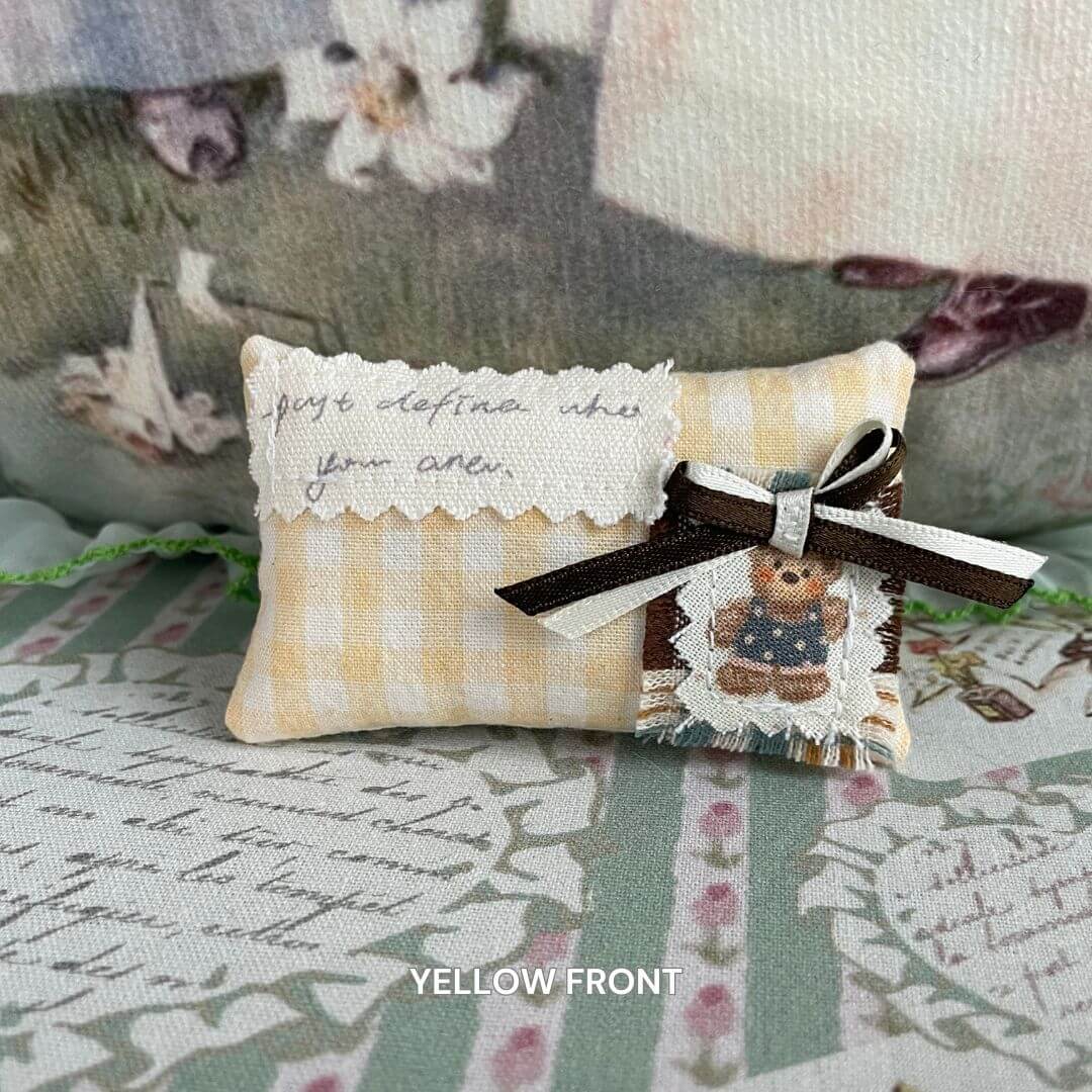 Handmade mini pillow with yellow gingham, teddy bear patch, and ribbon, ideal for cat or doll home decor. Cozy, cute accessory.