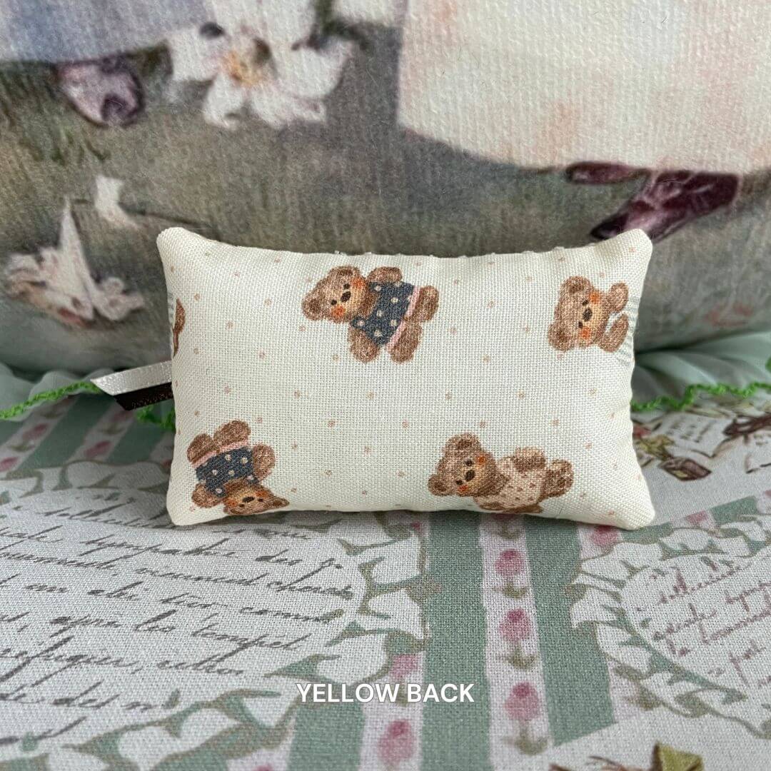 Handmade mini pillow with teddy bear print, perfect for dollhouse decor or miniature pet accessories, adding charm and warmth.