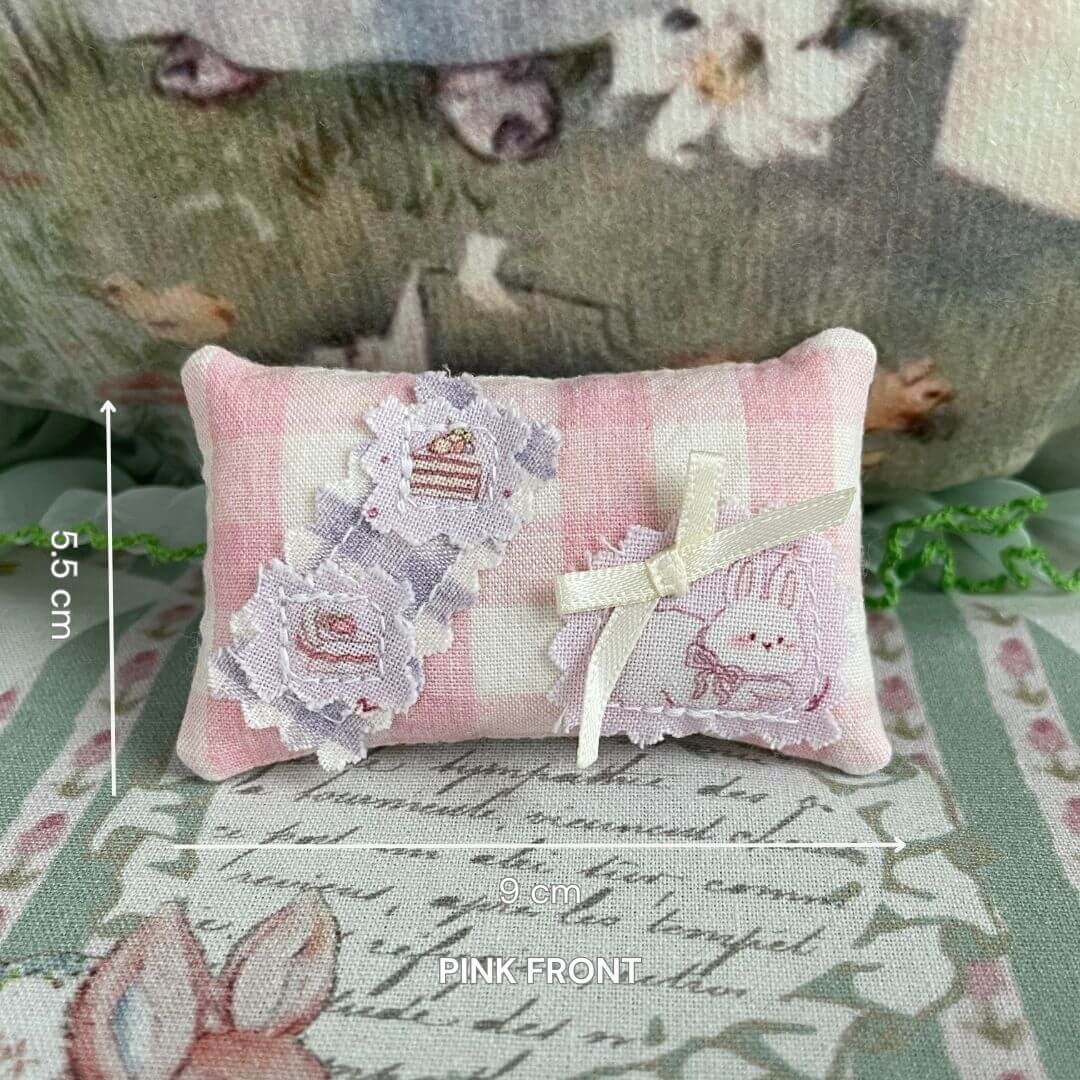 Handmade mini pillow with pink plaid design and cute bunny print, perfect accessory for dolls or small animal plush toys, 9cm x 5.5cm.