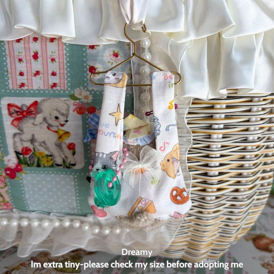 Little Hanger Pals: miniature animal decor featuring a fluffy kitten in a colorful handmade fabric sling, perfect for whimsical displays.