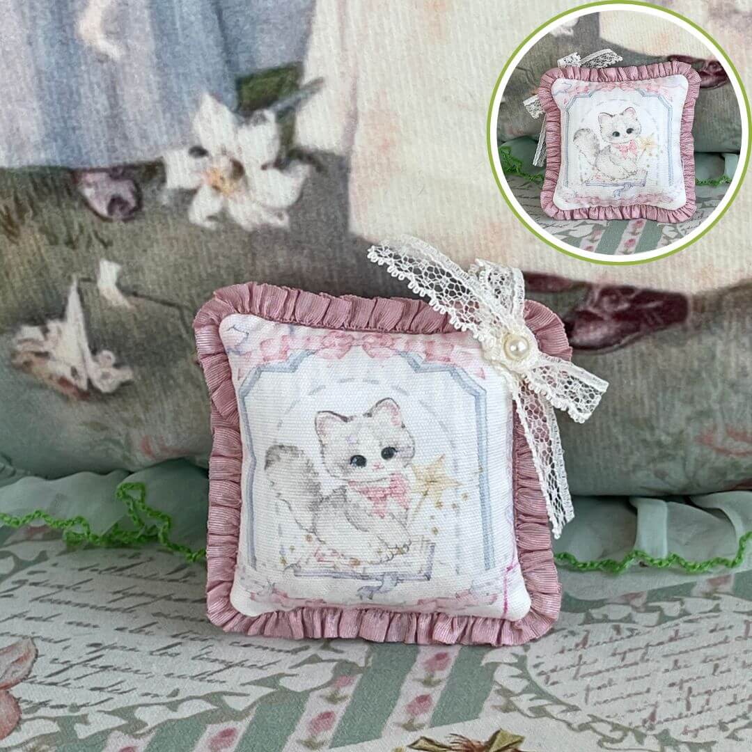 Handmade tiny cuddle critter cushion with kitten design, lace bow detail; perfect as a doll accessory or cute desk decor, 6x6 cm.