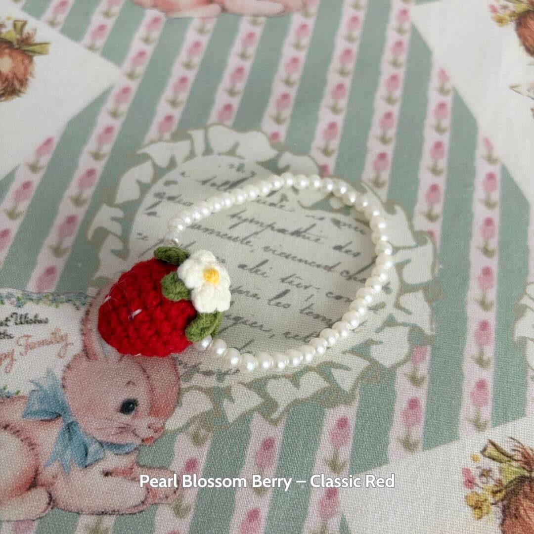 Handmade Snuggle Bits accessory featuring a cute strawberry purse with pearl beads, ideal for a fluffy kitten's fashion makeover.