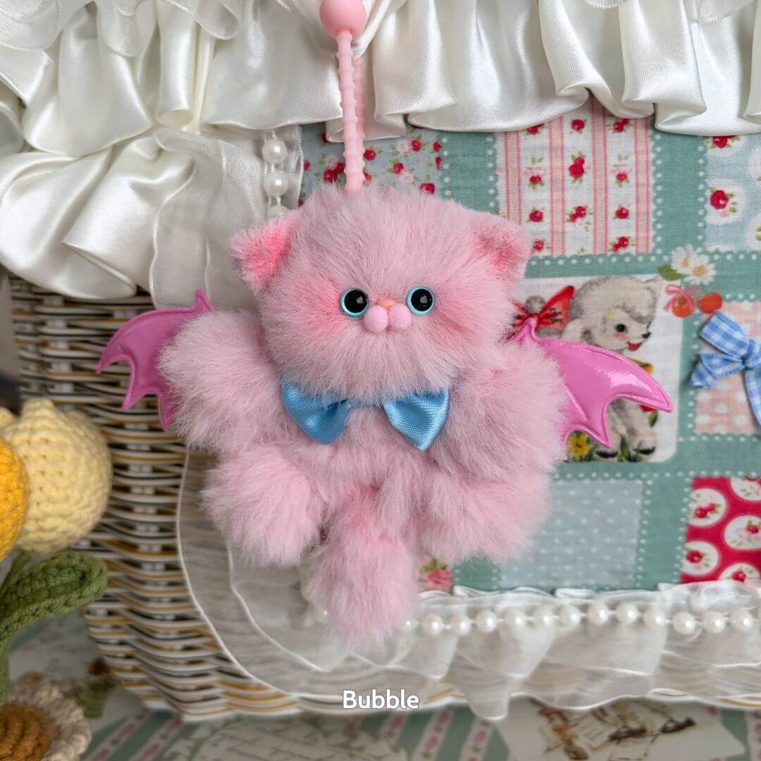 Cute handmade kitten with pink fluffy fur and bat wings, featuring a blue bow tie. Perfect for unique collectibles.