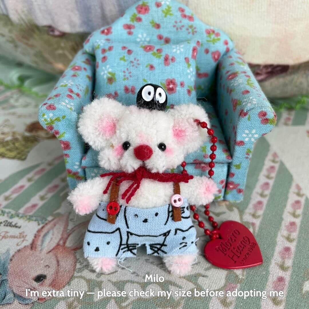Handmade miniature Pipe Cleaner Animals, fluffy white mouse in a blue outfit and red accessories, sitting in a cute chair.