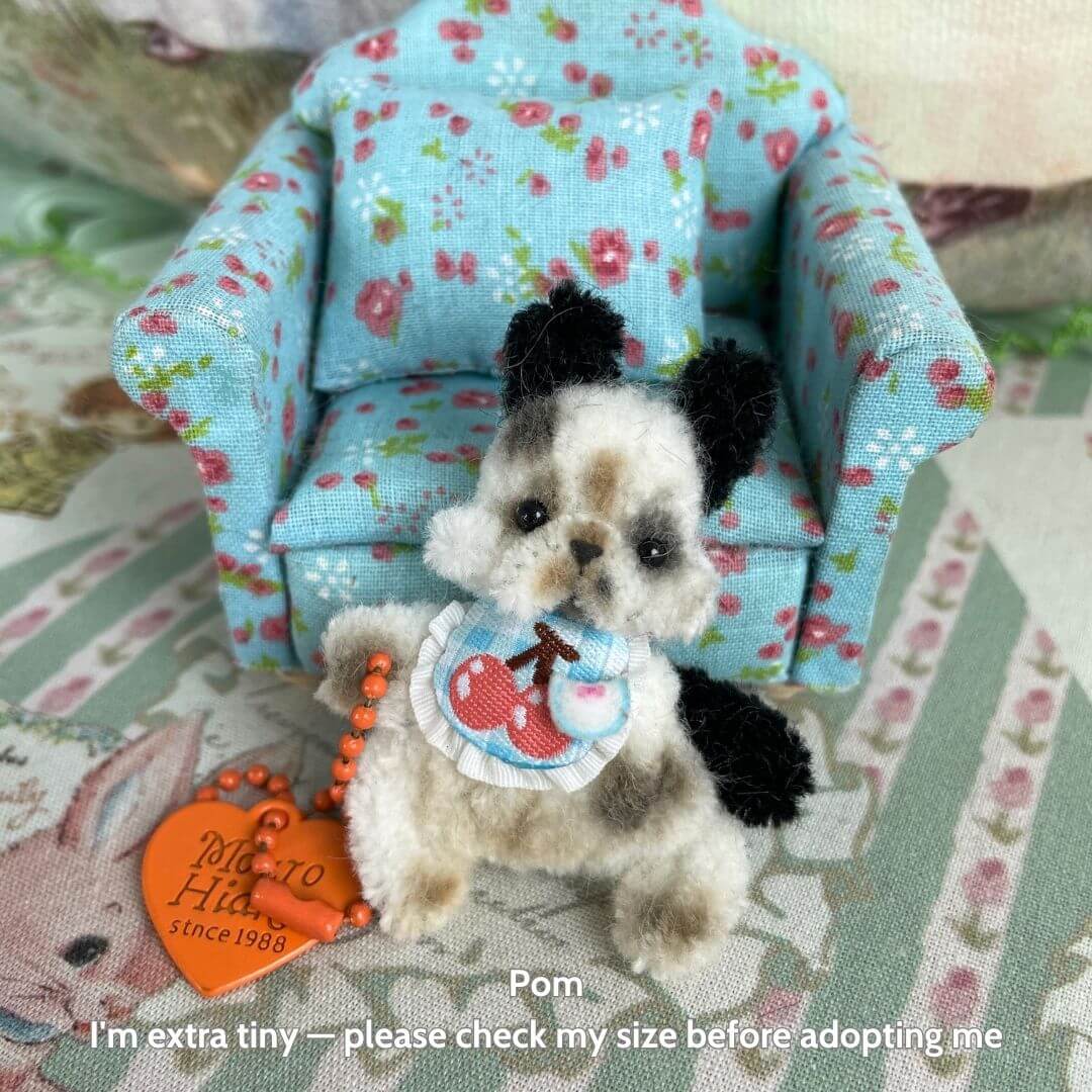 Cute handmade dog figurine in floral chair, fluffy puppy with black and white fur, miniature dog collectible.