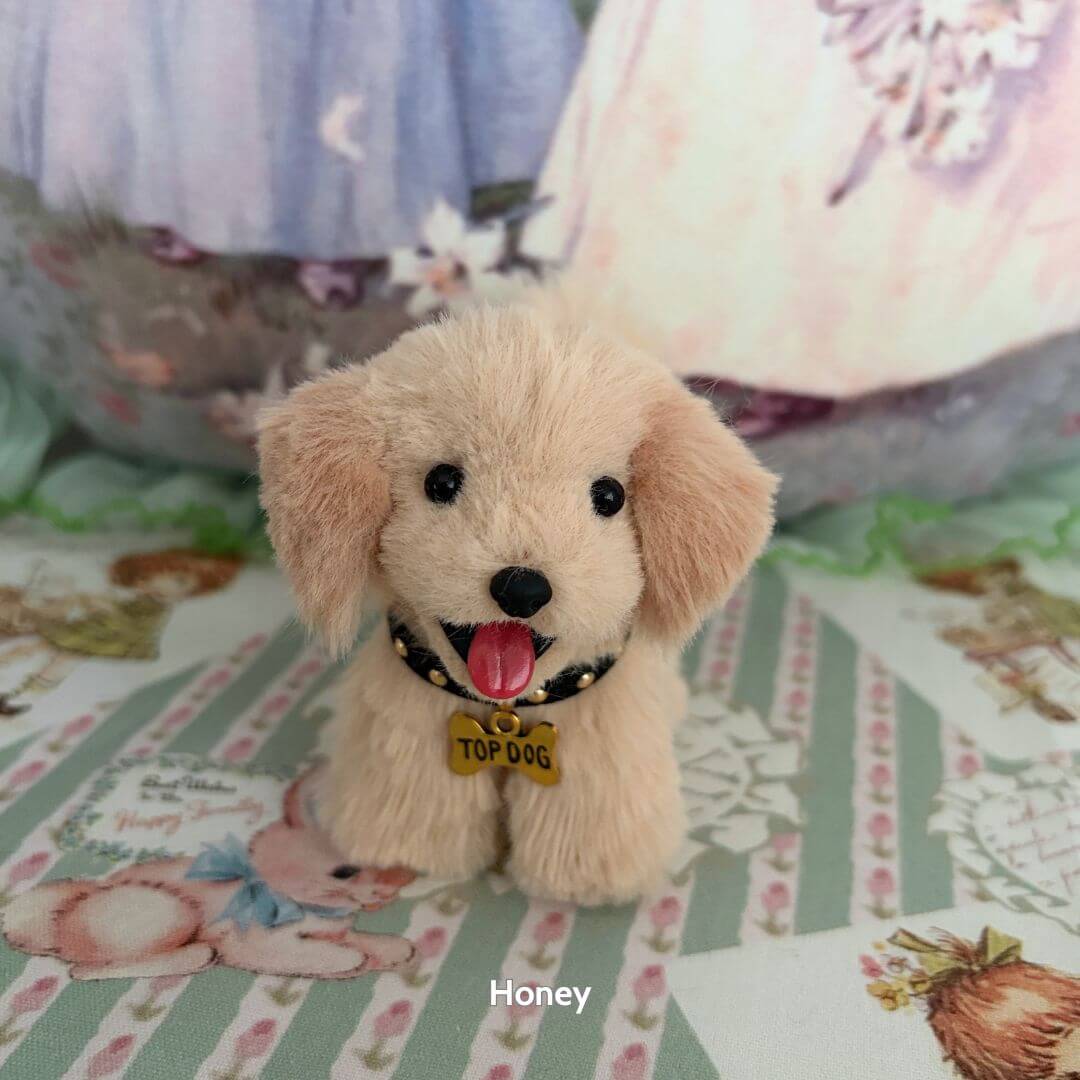 Lifelike Puppy Collection: fluffy beige puppy figurine wearing a 'Top Dog' collar, featuring a charming expression on a decorative background.