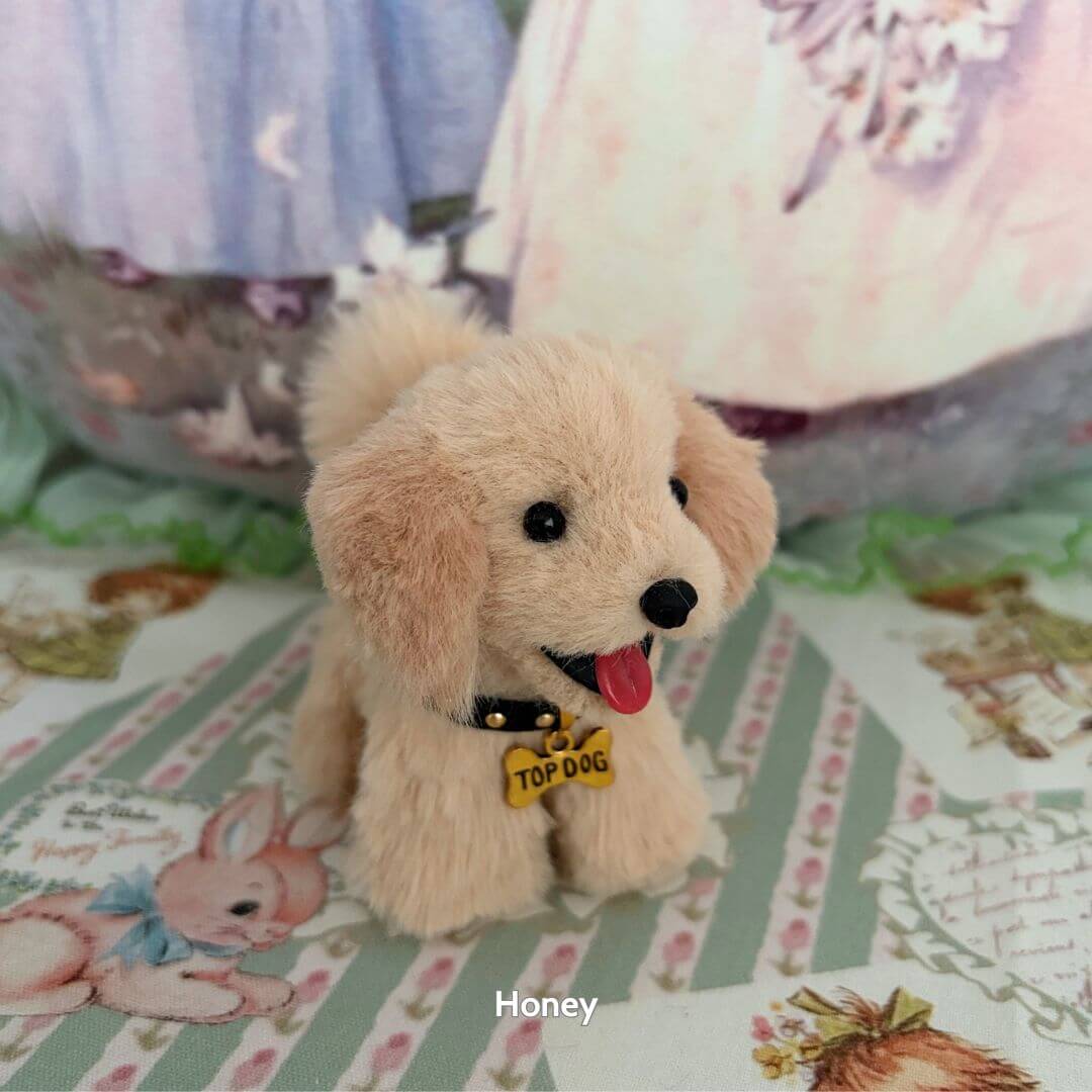 Adorable lifelike puppy from Lifelike Puppy Collection, wearing a 'Top Dog' tag, soft fur, expressive features on a decorative background.