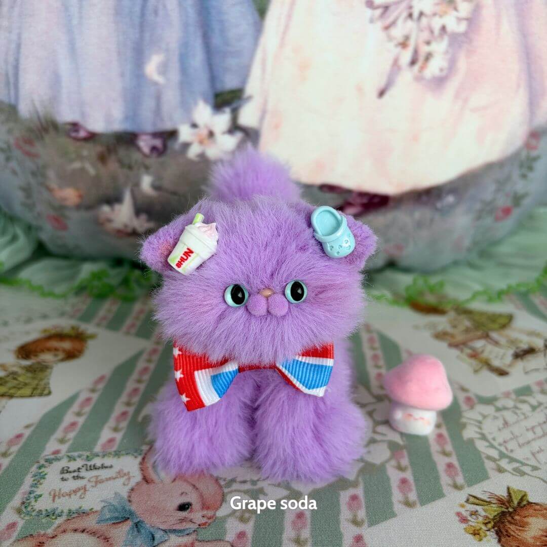 Alt Tag: Handmade kitten from the Fruity Kitten Collection, fluffy purple cat with a red bow, grape soda theme, cute accessories.