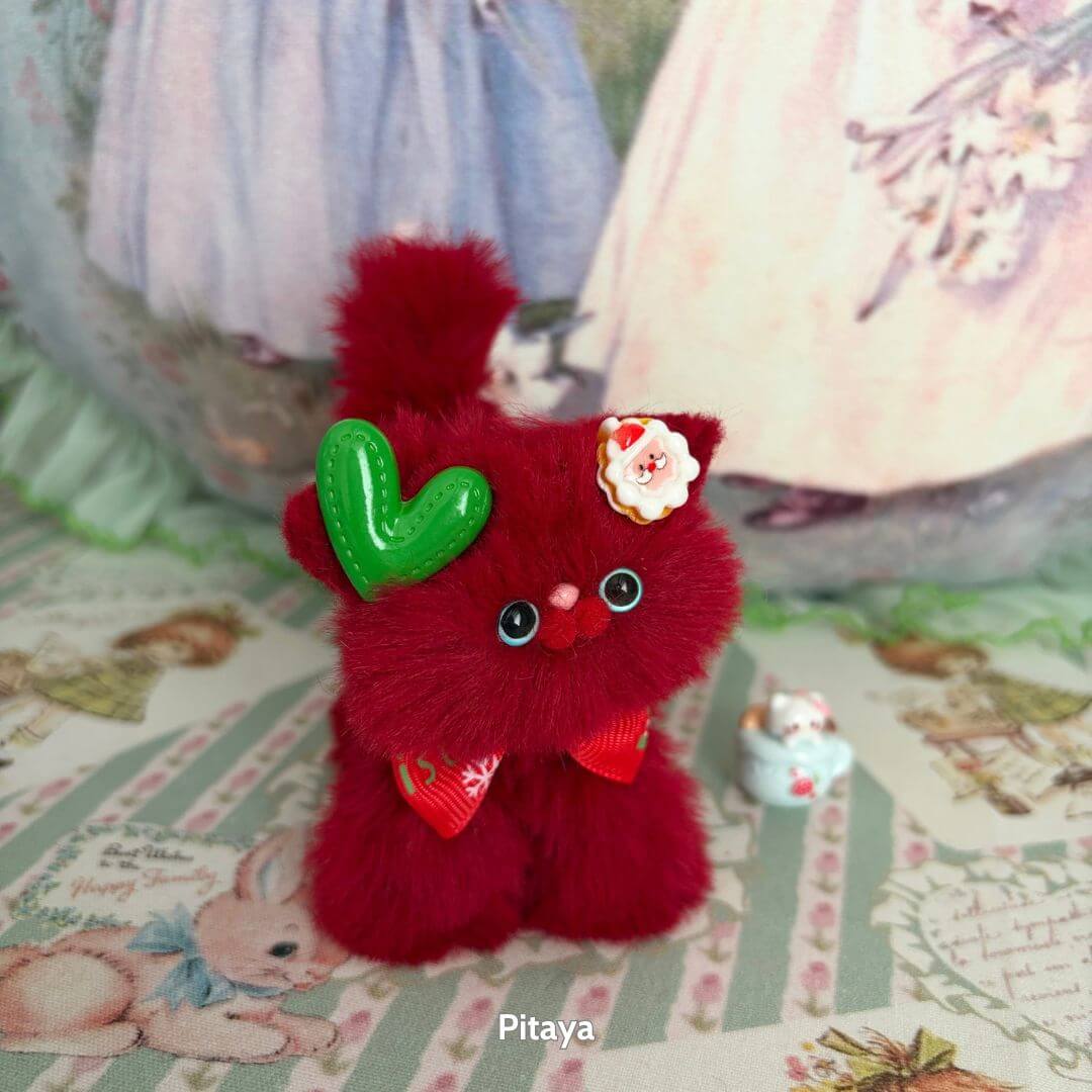 Fruity Kitten Collection: cute red handmade kitten figurine with heart-shaped accessory and floral bow, posing cutely on pastel backdrop.