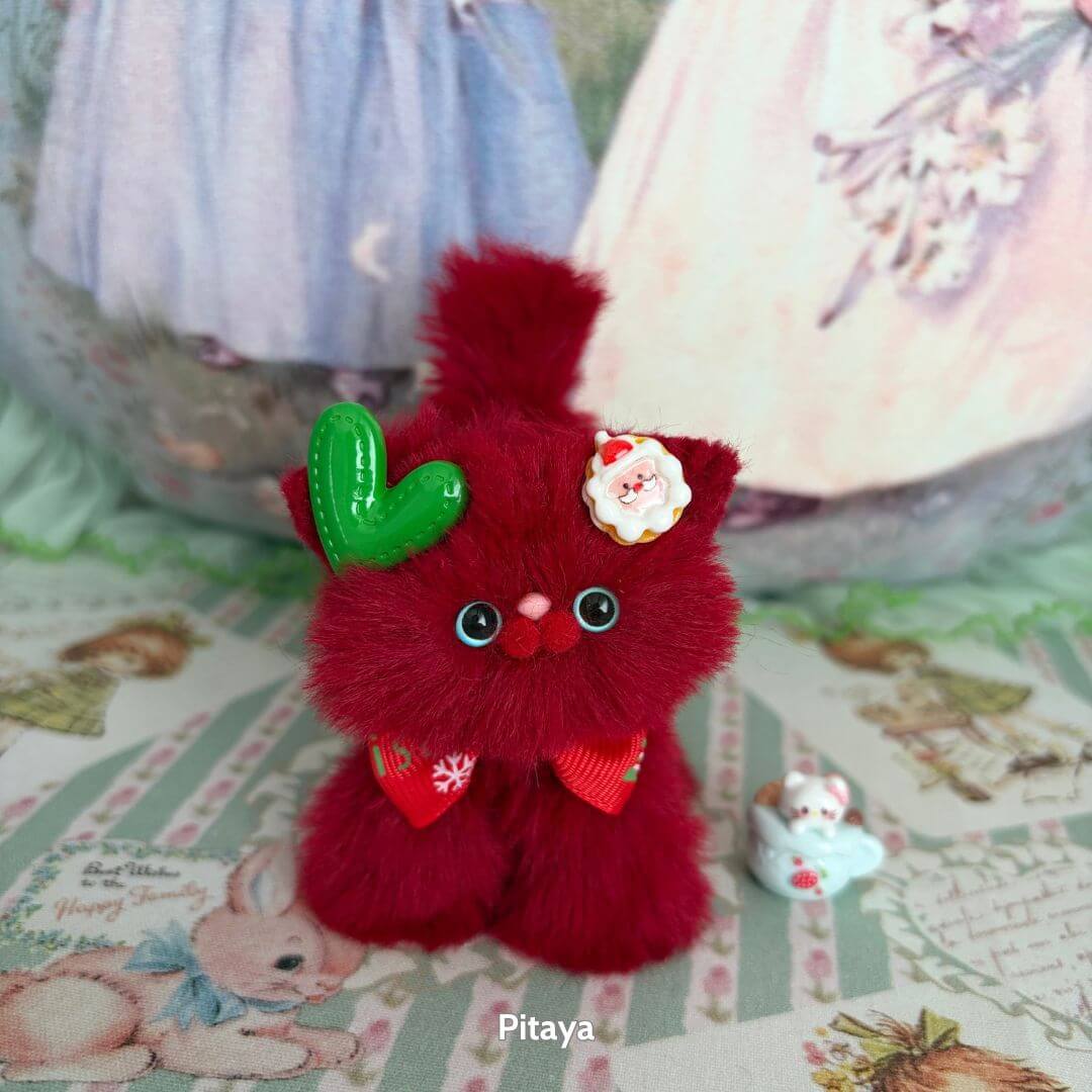 Cute red handmade kitten from the Fruity Kitten Collection, adorned with a green leaf and floral accessories.
