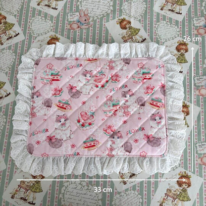 Handmade Sweet Tea Mat featuring a pink quilted surface with ruffled lace trim, charming floral patterns, and whimsical cat illustrations.