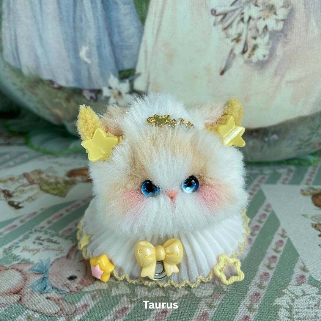 Zodiac Kitten Collection: Taurus kitten plush toy with yellow stars, horns, and bows, featuring blue eyes and soft faux fur.