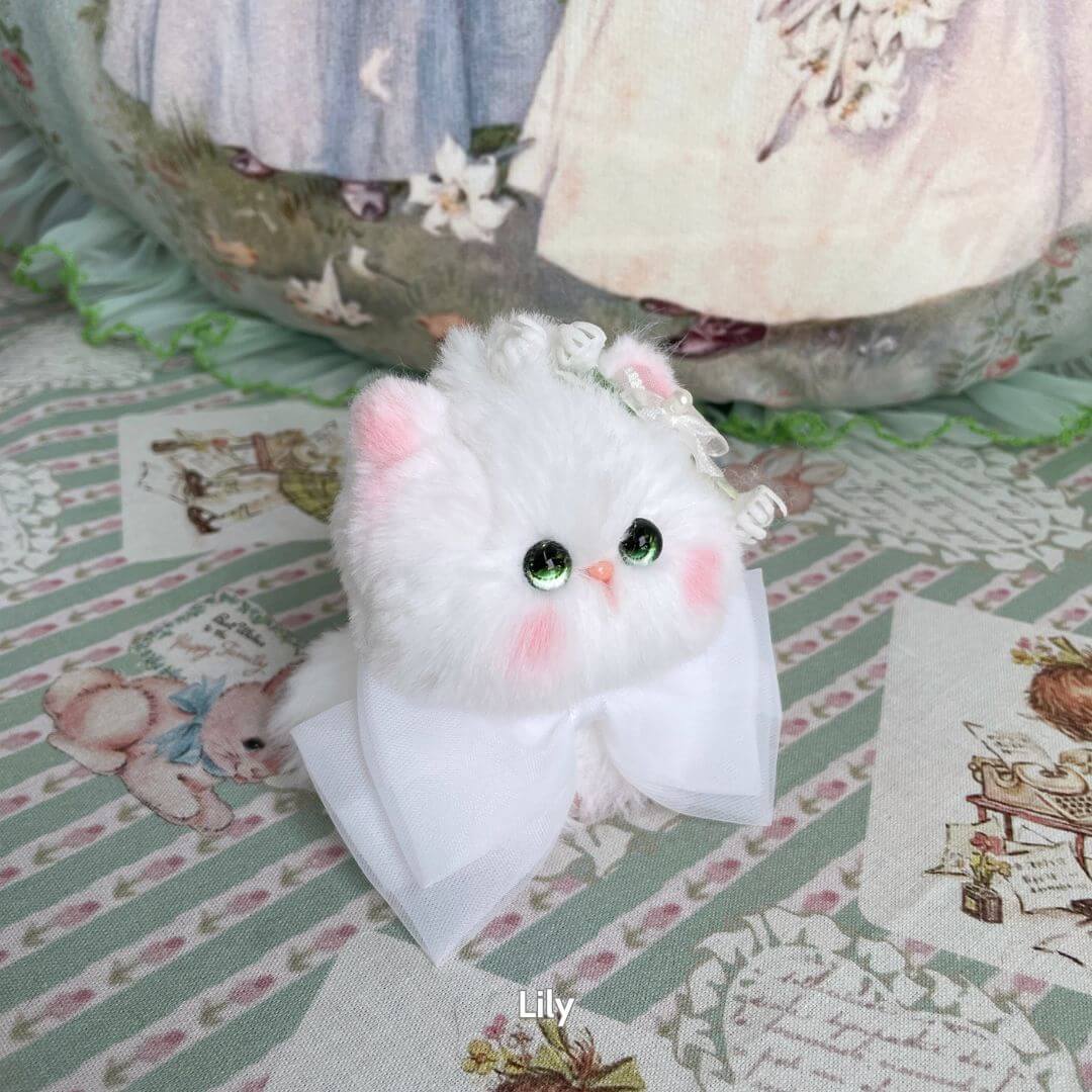 Adorable handmade kitten from the Blossom Kitten Collection, fluffy white with a bow, cute green eyes, and charming details.