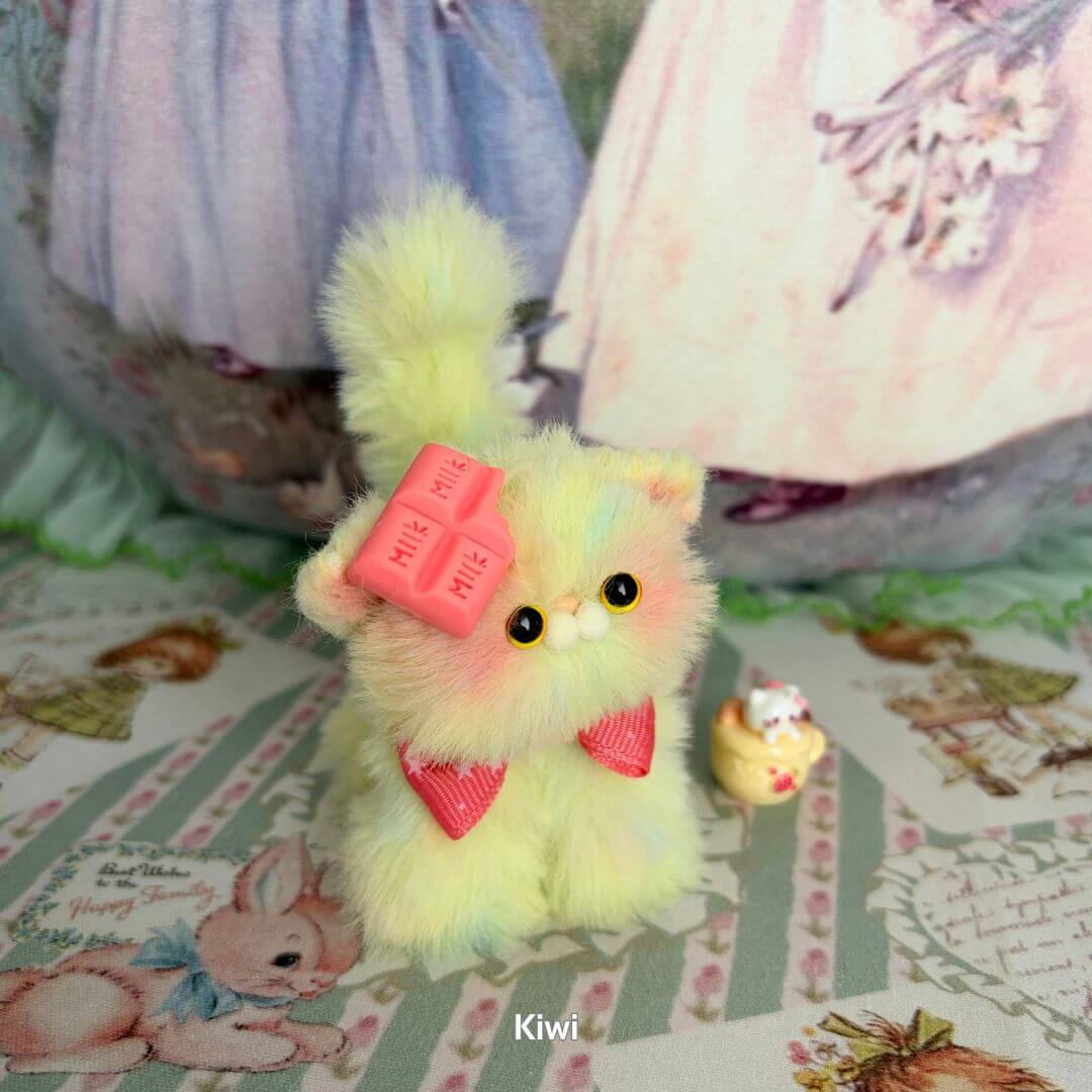 Miniature kitten in pastel yellow fur with pink accessories, inspired by kiwi fruit, from the Fruity Kitten Collection.