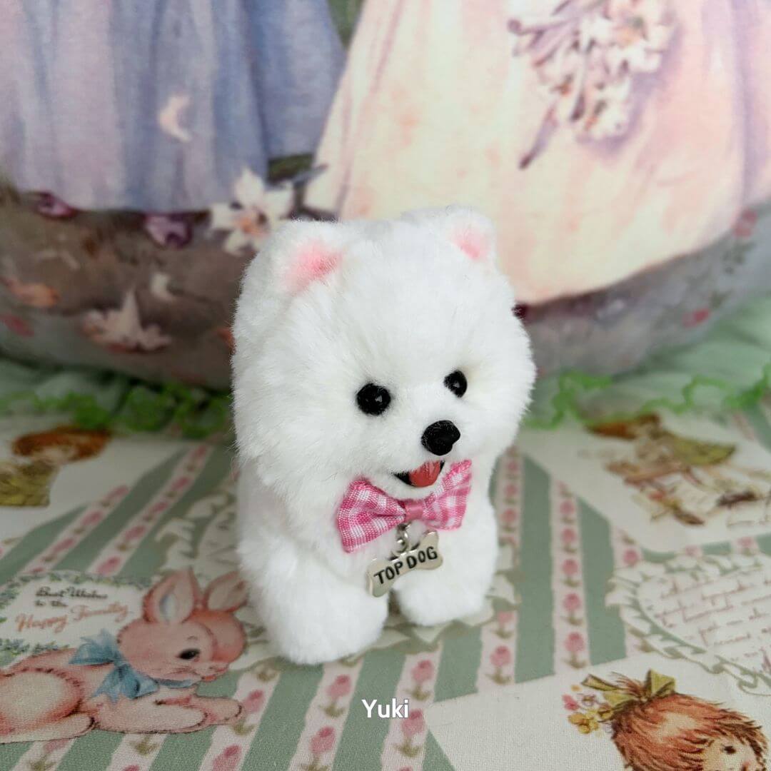 Lifelike Puppy Collection featuring a fluffy white puppy with a pink bow tie, sitting on a pastel decorative background.