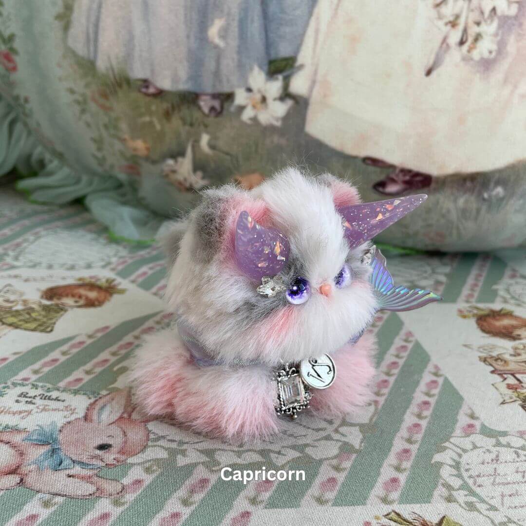 Handmade plush Capricorn zodiac kitten with faux fur, unicorn horn, and delicate charm accessories.