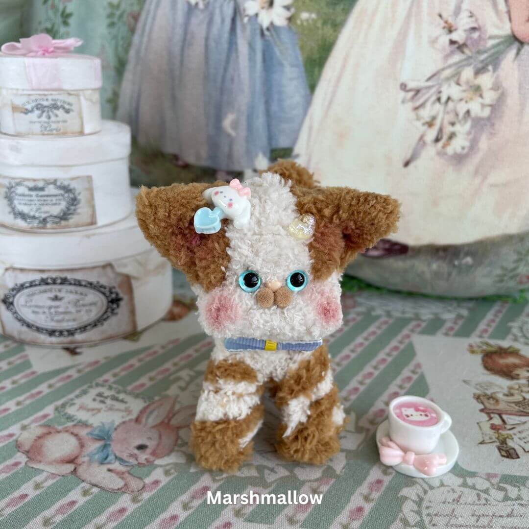 Handmade Devon Rex plush toy with big blue eyes, a blue bow, and decorative elements, set on a vintage-style background.