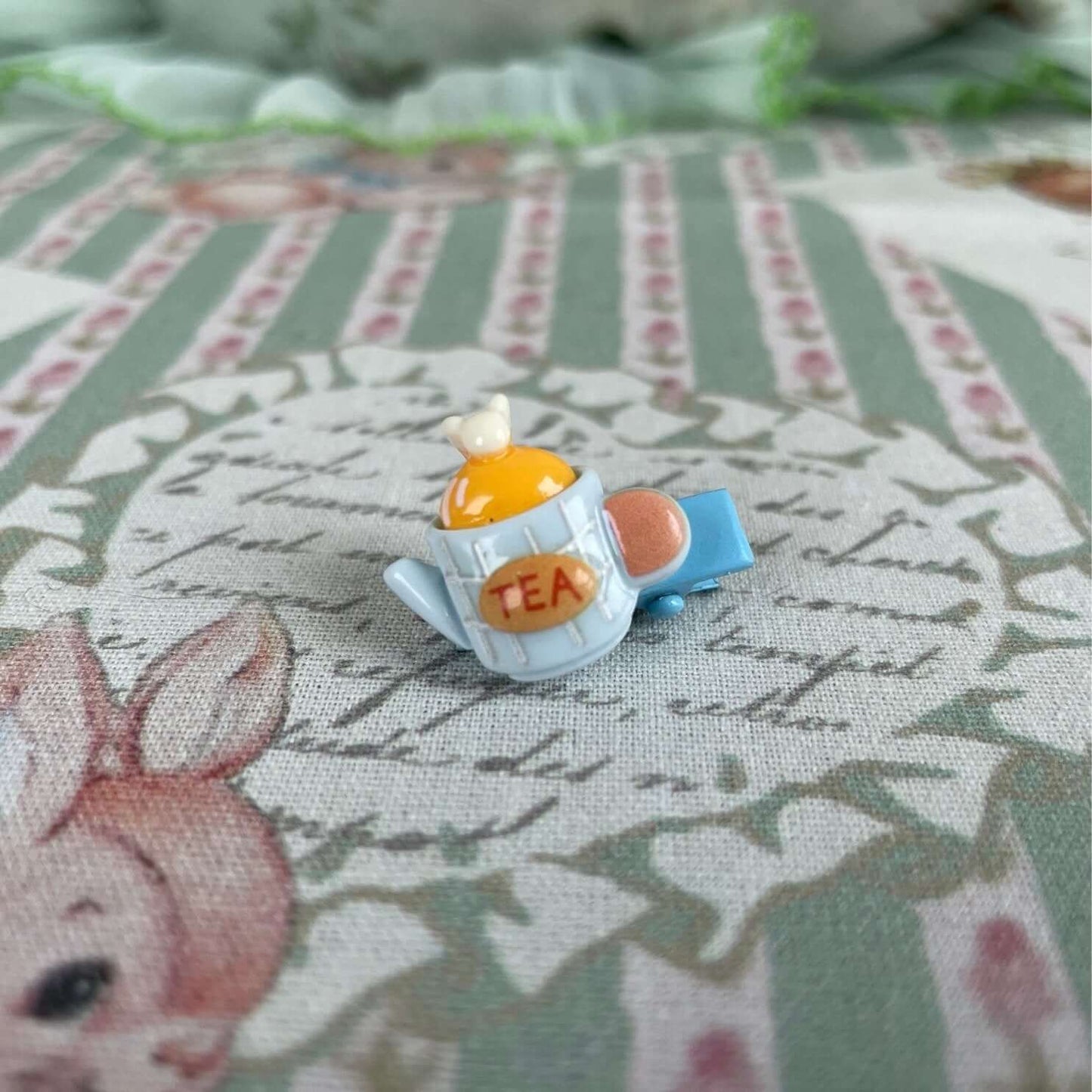 Handmade mini clip with a teapot design, perfect for decorating clothes or handcrafted plush kittens and puppies.