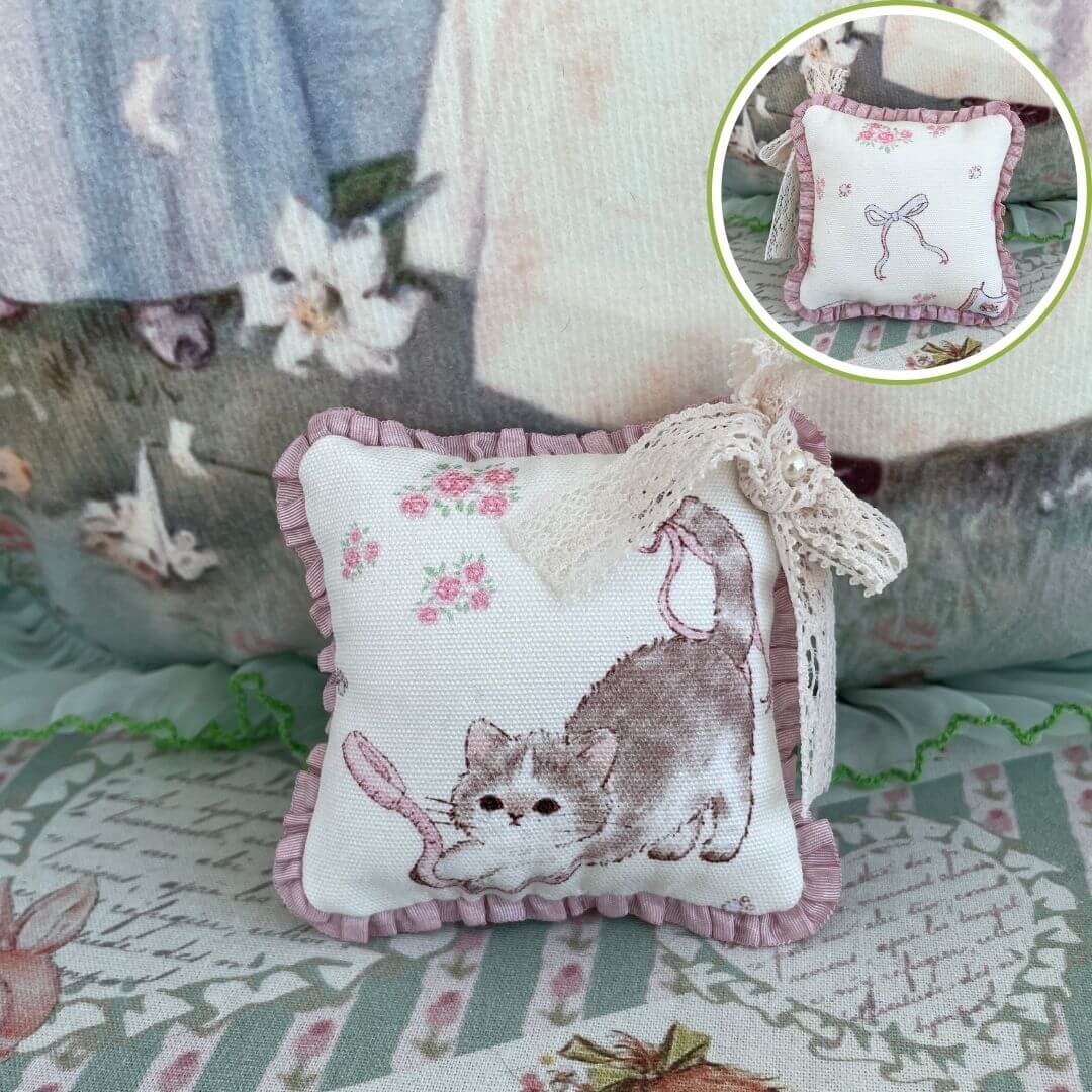 Handmade mini cuddle critter cushion with cat design, lace bow, and floral patterns, ideal as a plush toy or decorative desk accessory.