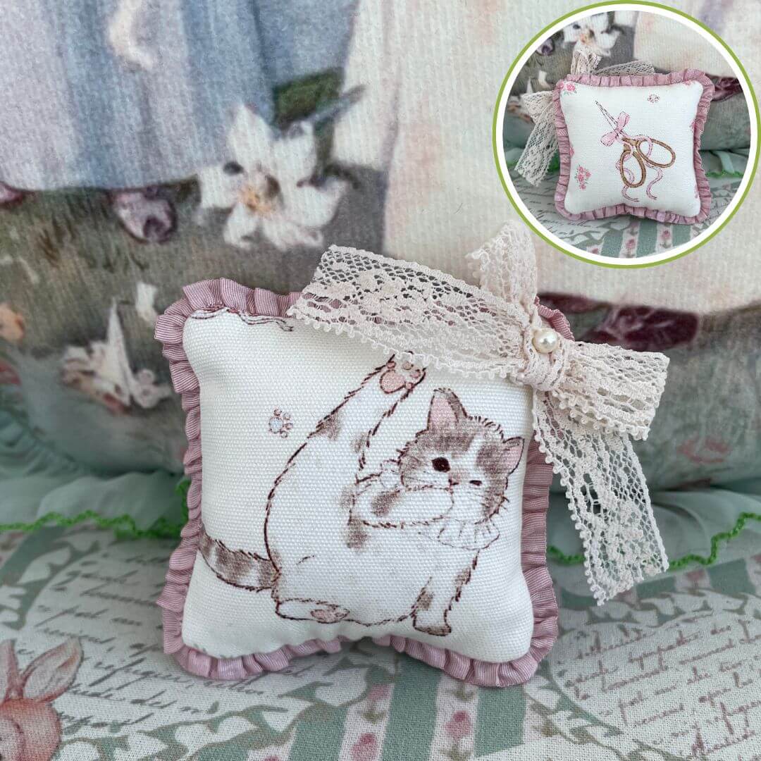 Handmade mini cuddle critter cushion featuring a kitten design with lace bow, perfect for dolls or as a decorative accessory.