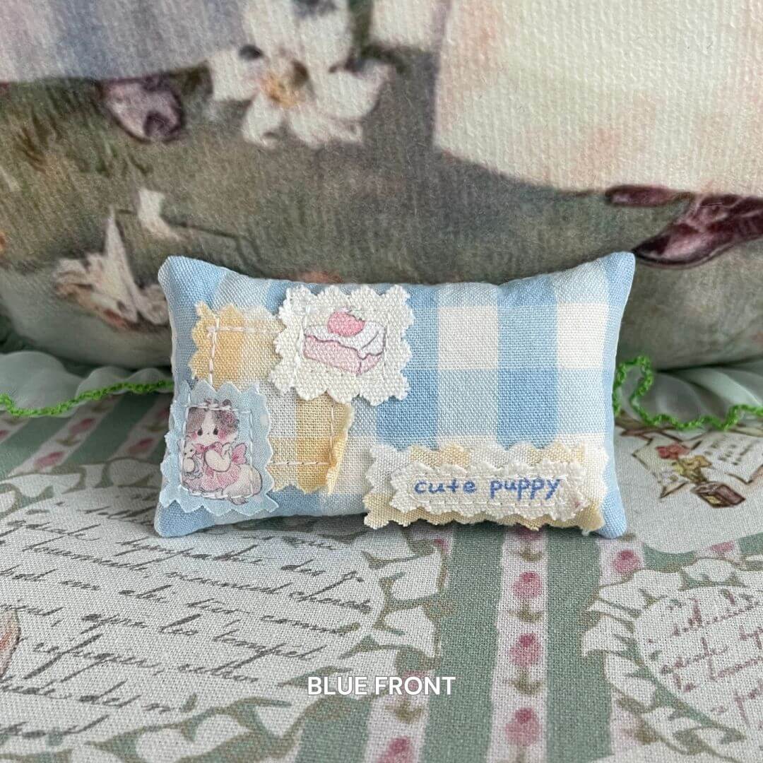 Handmade mini pillow with blue checkered fabric, illustrated with cute animals and "cute puppy" text, ideal for dollhouse decor.