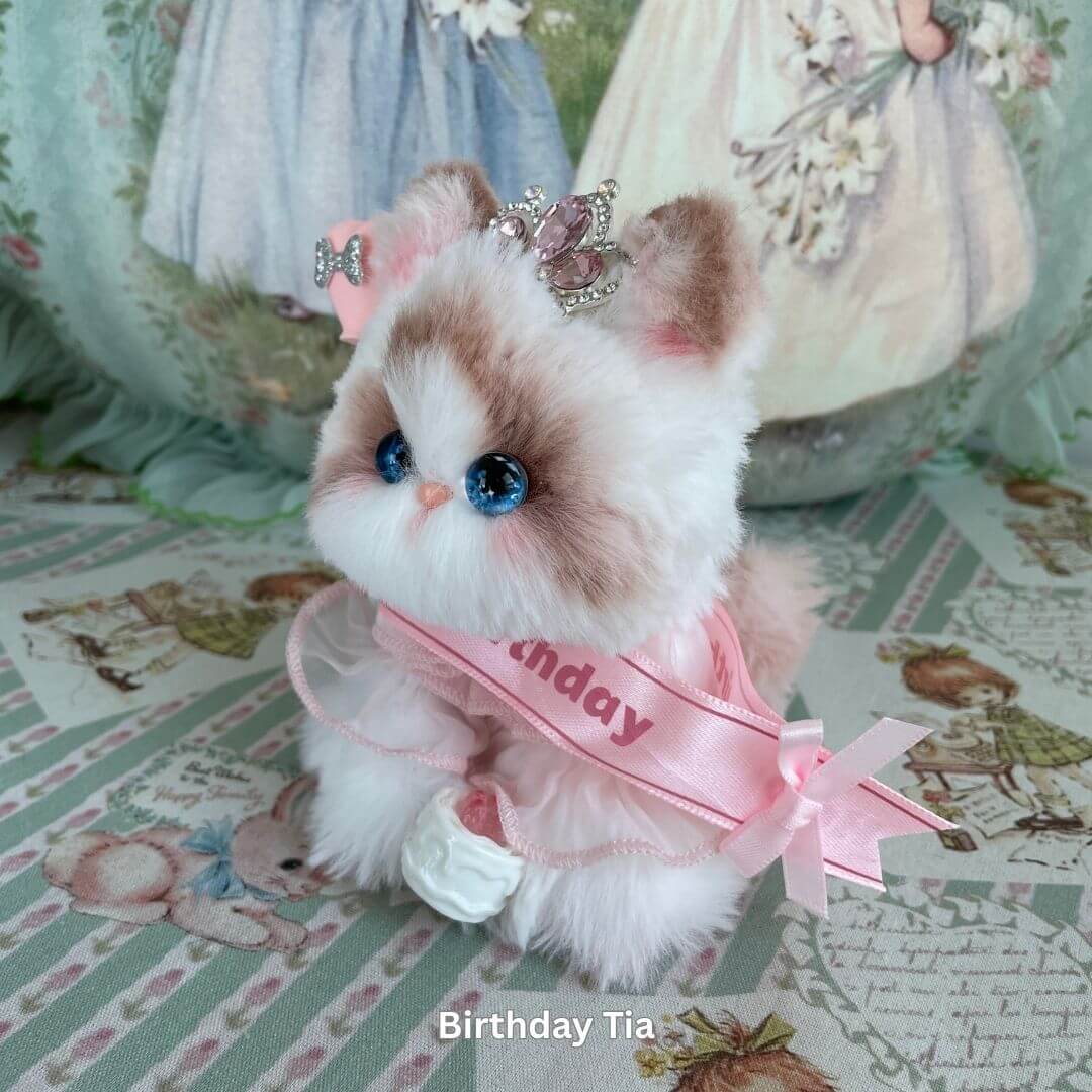 Handmade plush toy cat from Enchanted Big Paws Collection, wearing a pink birthday ribbon, perfect decor for cat lovers.