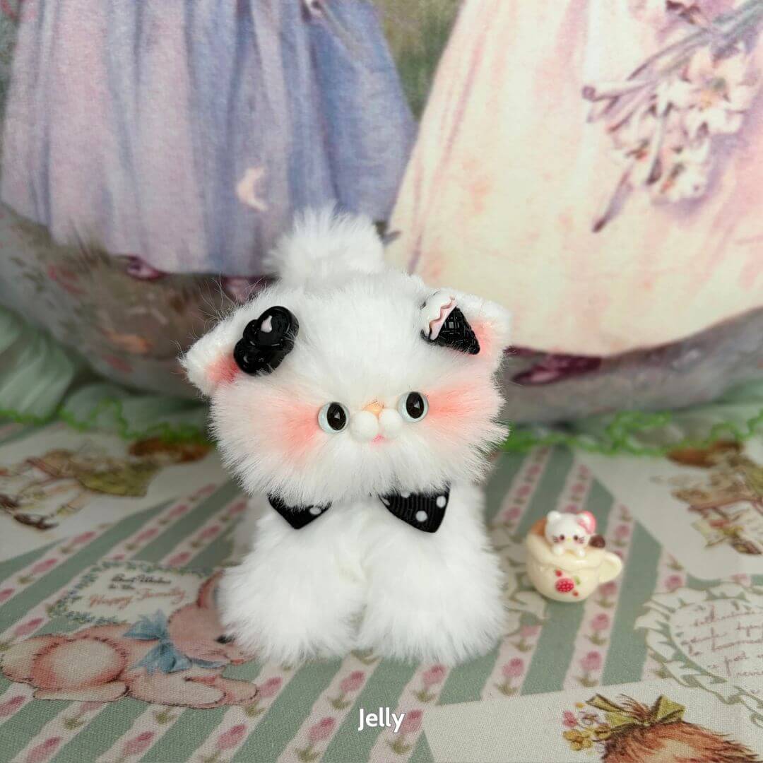 Adorable fluffy cat figurine from the White Kitten Collection, styled with a black bow and pastel accents, perfect for collectors.