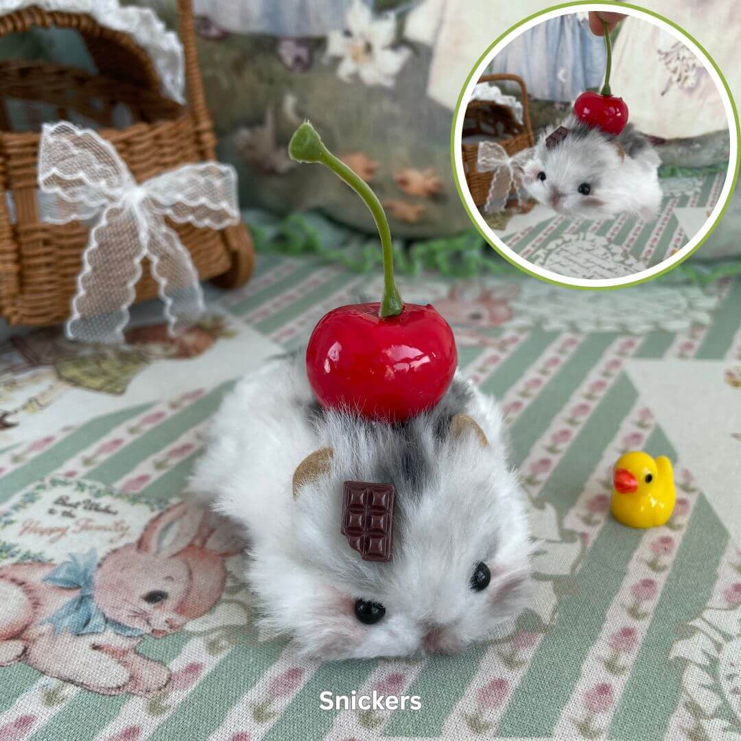 Handmade plush hamster figurine with cherry and chocolate details on a decorative surface.