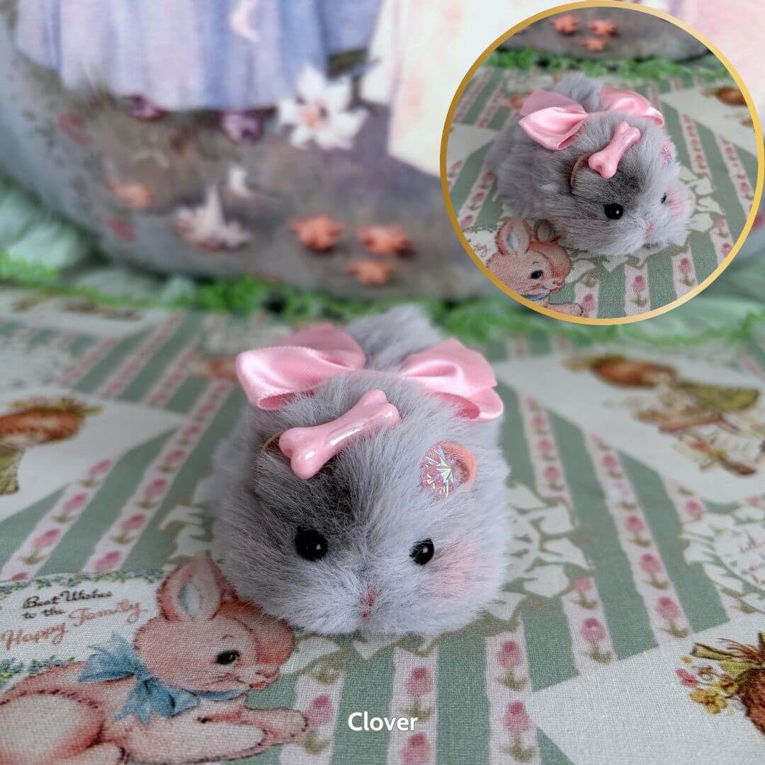 Lying Hamsters Figurines featuring a fluffy gray hamster with pink bows, lying cutely on a pastel-themed background.