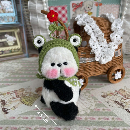 Handcrafted mini panda with movable joints, wearing crochet hat and apron; perfect as a small animal decoration or unique gift.