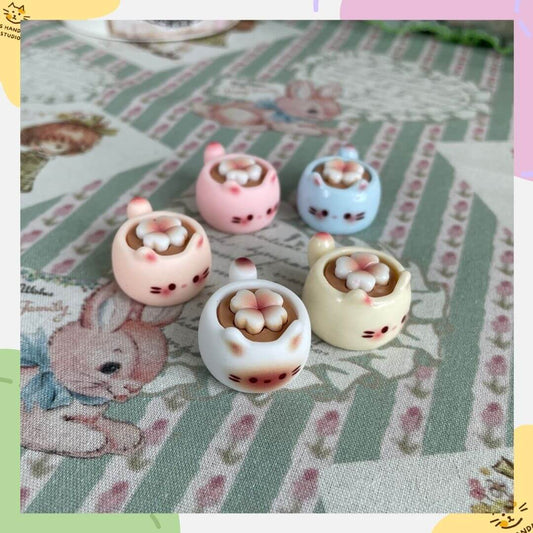 Miniature Lucky Kitty Cups on patterned tablecloth, decorative teacups ideal for dollhouse or gift for cat lovers and collectors.