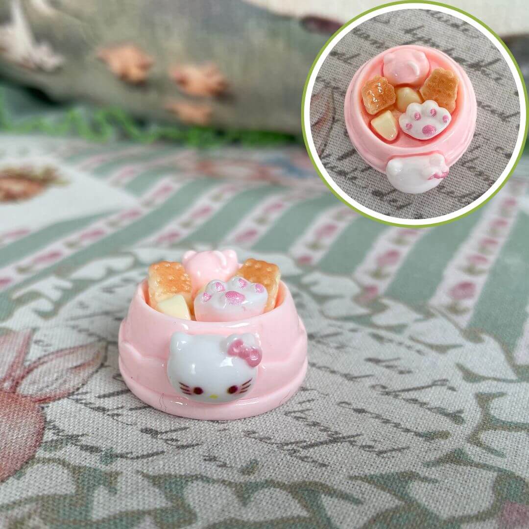 Pink cat-themed miniature dessert bowl with cute paw prints, featuring plush toy decorations designed for small animals.