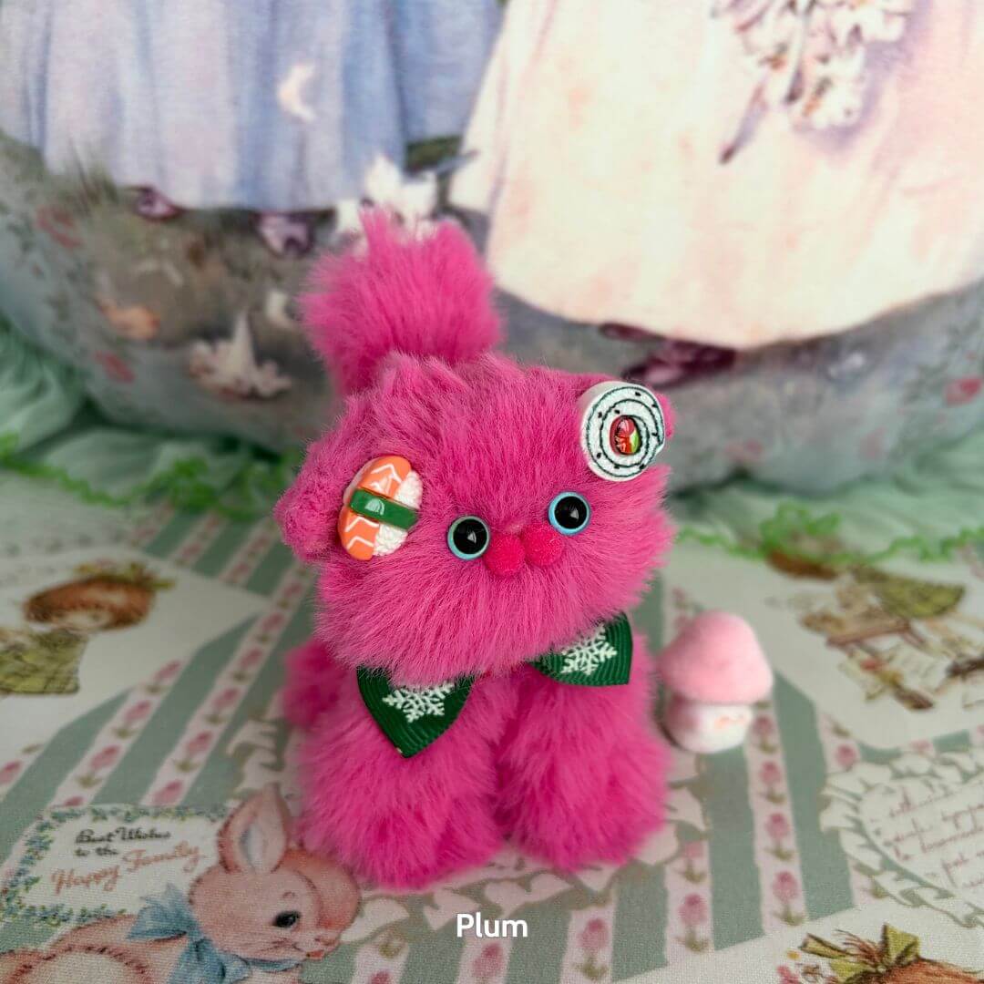alt tag: Fruity Kitten Collection features a fluffy pink kitten with buttons and a green bow, inspired by plum, handmade collectible decor.