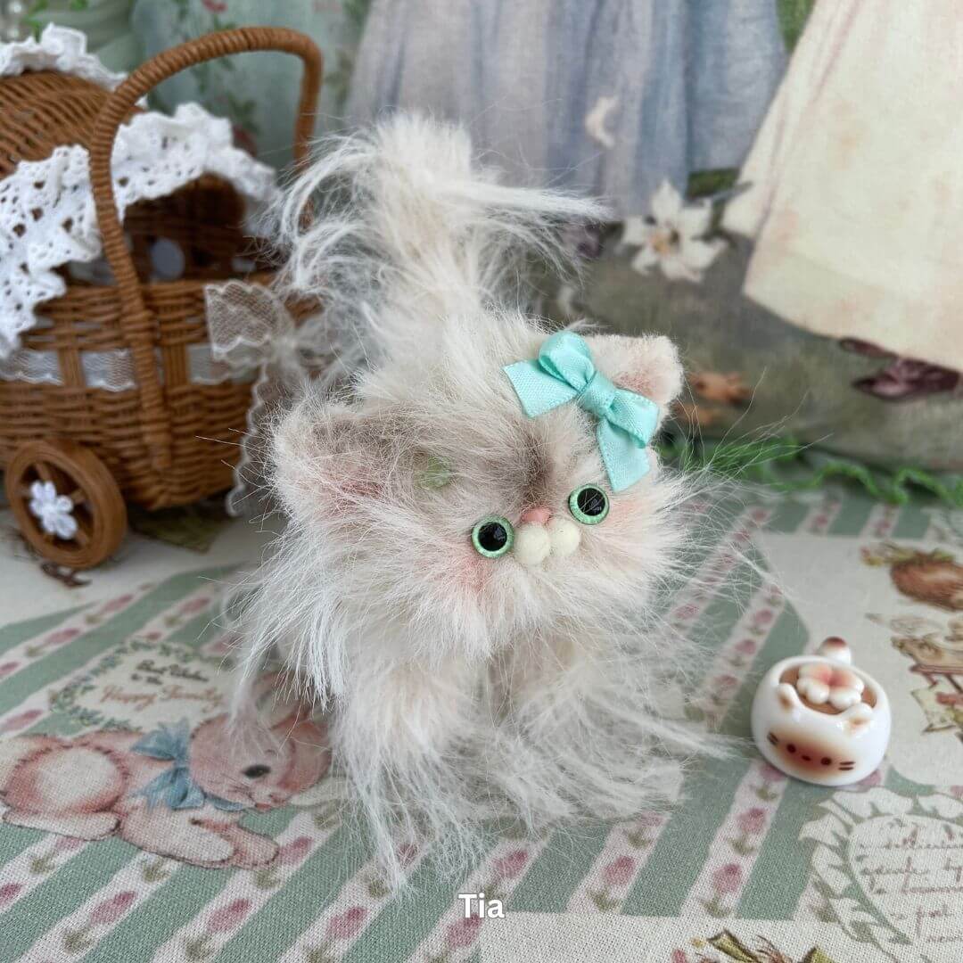 Fluffy handmade Siberian kitten plush with pastel fur, turquoise bow, and faux milk accessory from the Siberian Snuggles Collection.