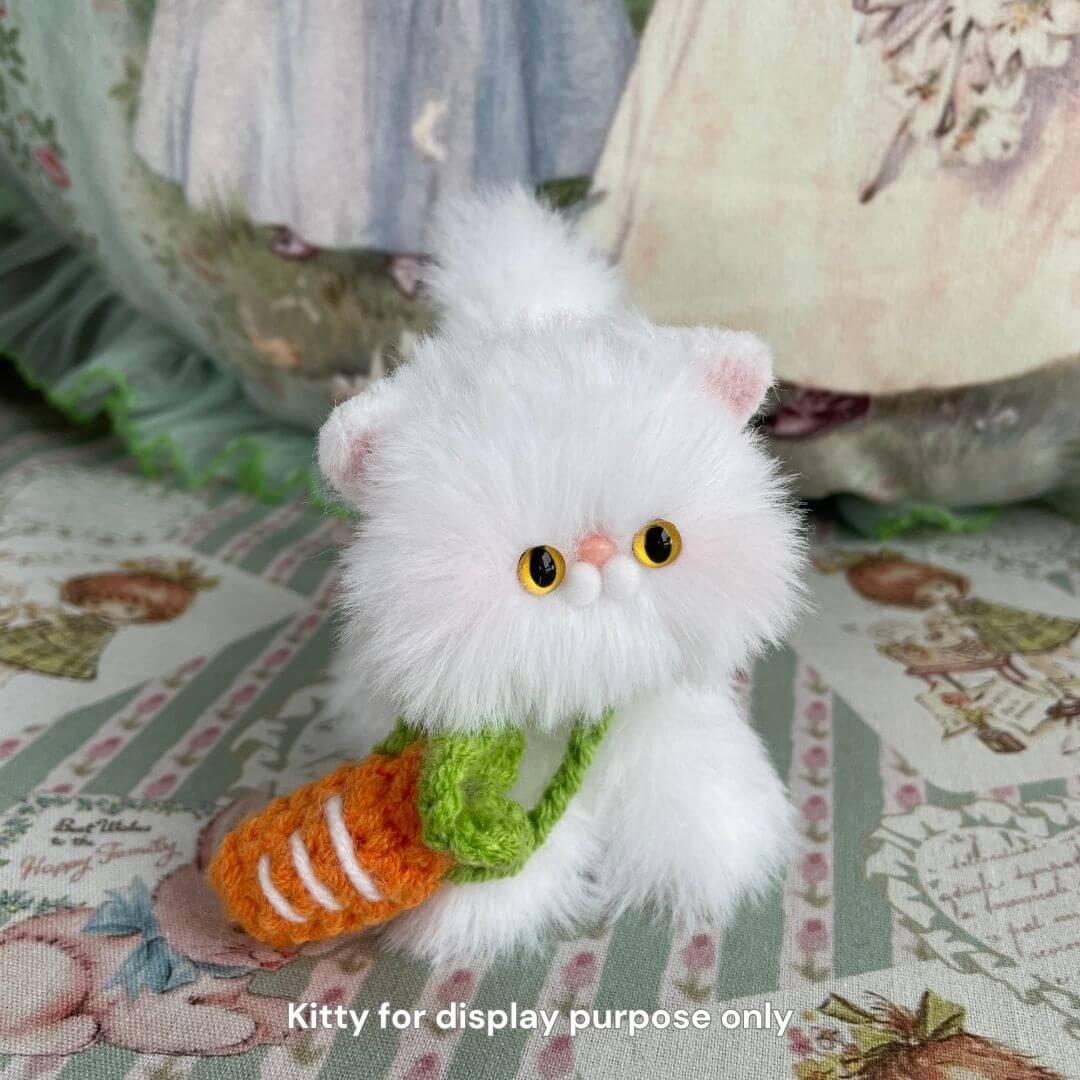 Plush white kitten with a cute carrot sling accessory, part of the Snuggle Bits handmade collection for a stylish pet makeover.
