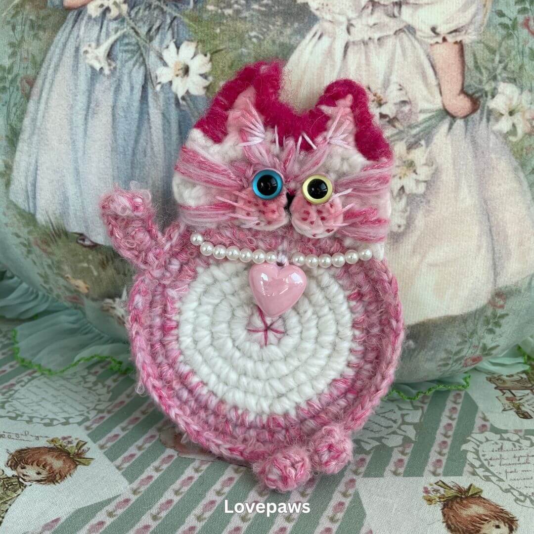 Handmade pink cat-themed plush toy with pearl necklace, crafted for decoration or as an accessory, perfect for feline lovers.