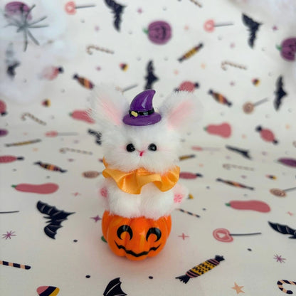 White long-eared friend on a pumpkin with a purple witch hat and orange ruff.