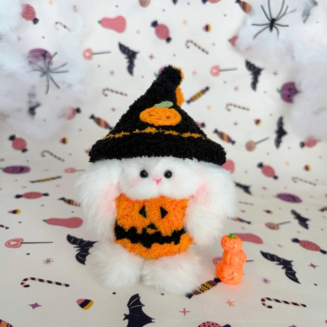 White pink-cheeked friend in a black witch hat and orange pumpkin outfit.
